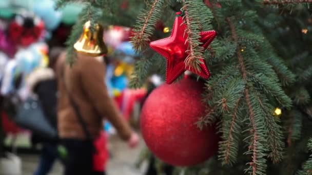 Närbild Röd Jul Dekorationer Hängande Ett Naturligt Nyårsträd Stadsmässa Folkmassa — Stockvideo