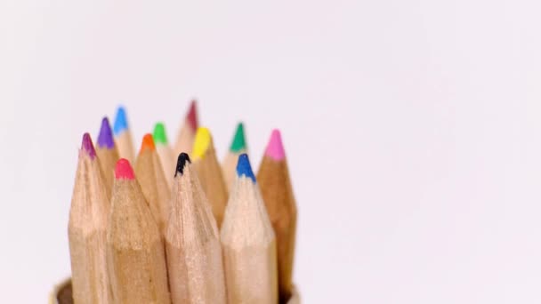 Ensemble de crayons en bois multicolores de différentes couleurs tournant sur un fond blanc. Objet isolé avec espace de copie. Concept de retour à l'école.
