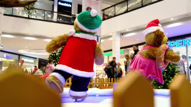 Due enormi bambole di orso artificiale vestite con costumi da Babbo Natale stanno pattinando. — Video Stock