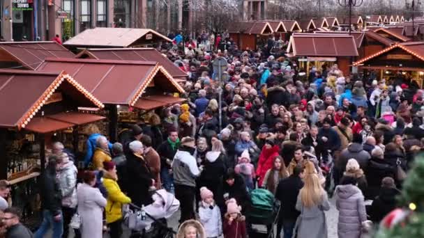 Emberek tömegei egy díszített karácsonyi vásáron a város főterén, nap mint nap. — Stock videók