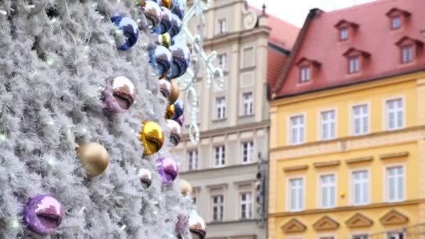 Karácsonyi dekoráció egy fehér szintetikus fenyőfán egy európai városban — Stock videók