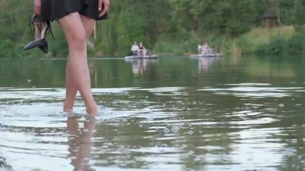 Wanita Muda Yang Menarik Mengenakan Gaun Hitam Pendek Berjalan Sungai — Stok Video