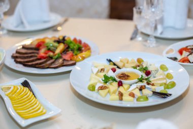 Lüks bir restoranda servis edilen beyaz bir ziyafet masasında lezzetli yemekler. Kimse yok..