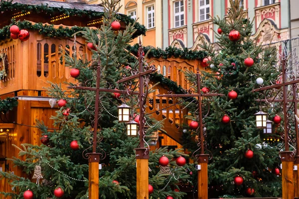 Klasik sokak fenerleri ve LED çelenklerle süslenmiş yeni yıl ağaçlarıyla süslenmiş kırmızı noel baloları Central City caddesindeki şenlikli Noel fuarında.