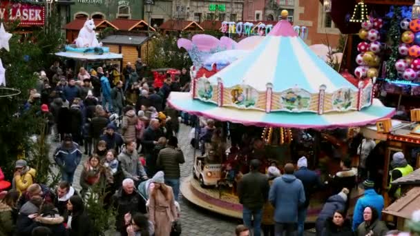 Folle di persone in una fiera di Natale decorata in una piazza centrale festiva di giorno. — Video Stock