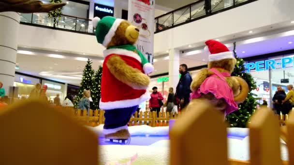 Couple of big artificial bears dressed in Santa Claus suites are skating. — Stock Video