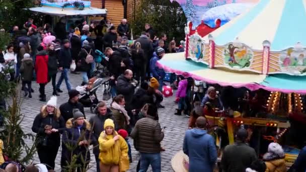 Egy csomó ember egy díszes karácsonyi vásáron egy ünnepi főtéren.. — Stock videók