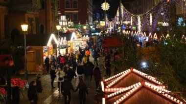 İnsanlar Noel ışıklarının arasında dinleniyor, yürüyor..