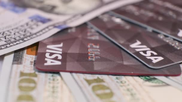 Amerikaanse bankbiljetten van 100 dollar en creditcards Visa op roterende tafel. — Stockvideo