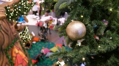 Altın top ve çelenk dekore edilmiş alışveriş merkezindeki yapay Noel ağacında.