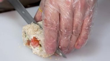 Erkek şef bir Japon restoranında suşi sarması kesmiş..