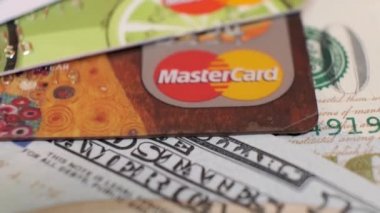 100 Dolarlık Amerikan Banknotları ve Dönen Masa 'da Plastik Kredi Kartları Mastercard. Yakın plan, Saha 'nın Sığ Derinliği. LOS ANGELES, ABD - Eylül 2020