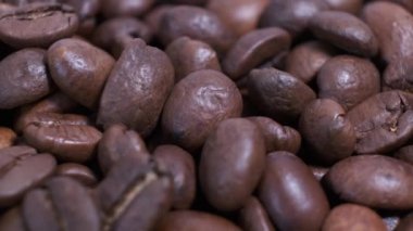 Dönen masanın üzerinde kavrulmuş kahve çekirdekleri. Aromatik kahve taneleri dönüyor..