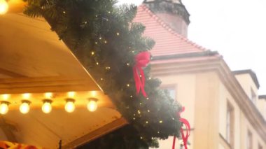 Işıklarla süslenmiş bir Noel 'de buhar ve eski şehir merkezinde kış günü bir panayırda köknar ağacı ahşap çatılı bir kafe..