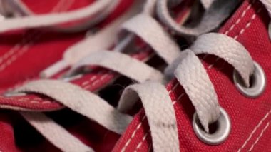 Dönen kırmızı spor ayakkabıları yakın plan beyaz bağcıklı Converse. Spor ayakkabılar, gençlik modası.
