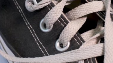 Siyah spor ayakkabıların yakın plan görüntüsü beyaz bağcıklı Converse. Spor ayakkabılar, gençlik modası.