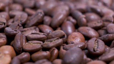 Dönen masanın üzerinde kavrulmuş kahve çekirdekleri. Aromatik kahve taneleri dönüyor..