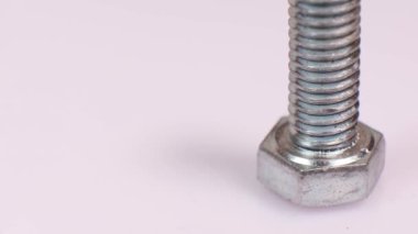 Galvanize metalik vidayı yakın plan çekiyoruz. Paslanmaz çelik cıvata beyaz arka planda izole edilmiş. Boşluğu kopyala.