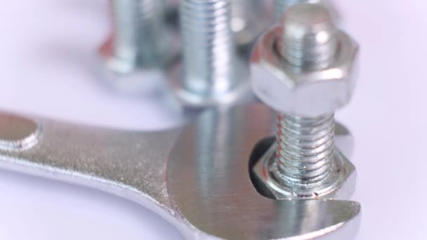 Grupo rotativo de parafusos metálicos galvanizados, chave inglesa e porca close-up. — Vídeo de Stock