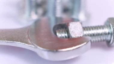 Dönüşümlü galvanize metal vidalar, ingiliz anahtarı ve fındık yakın çekim. Beyaz zemin üzerinde paslanmaz çelik cıvatalar izole.
