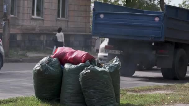 Mehrere Plastiktüten Voller Müll Auf Der Straße Autos Fahren Die — Stockvideo