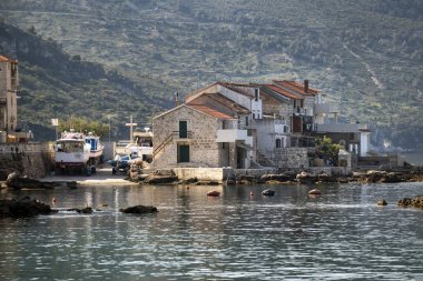 Hırvatistan 'da ada Vis Komiza limanında balıkçı tekneleri ve eski taş evler