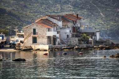 Hırvatistan 'da ada Vis Komiza limanında balıkçı tekneleri ve eski taş evler