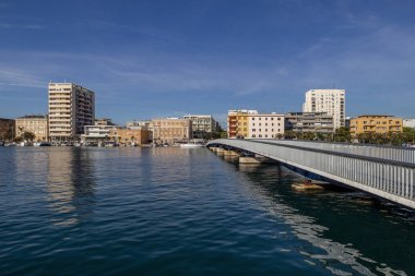 İnsanlar, Hırvatistan 'ın güneşli bir gününde Zadar kasabasında Jazine Körfezi 'ndeki şehir köprüsünü geçip