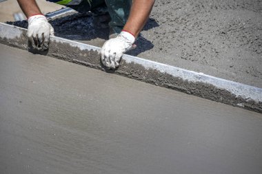 Beton köprünün onarımı ve yenilenmesi. Şantiyede işçi doğrultma ve taze beton yumuşatma