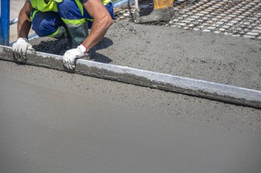 Beton köprünün onarımı ve yenilenmesi. Şantiyede işçi doğrultma ve taze beton yumuşatma