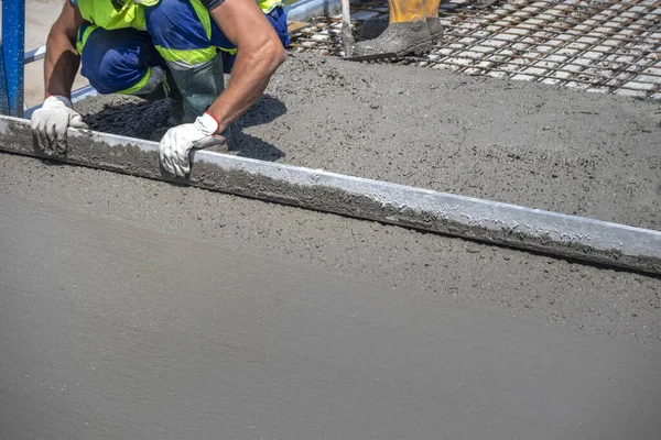Repair and renovation of concrete bridge. Worker straighten and smoothing fresh concrete on a construction site