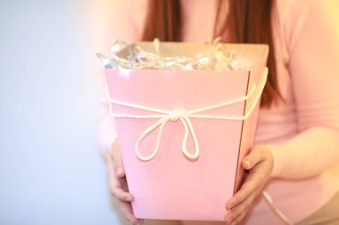 Nazik kız pembe hediye kutusu ile. Parlak ışıklar içinde hediye var. Sürpriz 