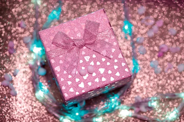 Růžová Dárková krabice s malými srdce na fialové jiskřivé pozadí. — Stock fotografie