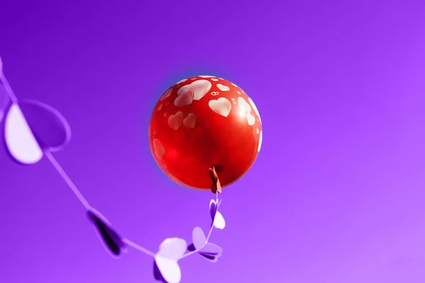 Um balão vermelho no céu roxo . — Fotografia de Stock