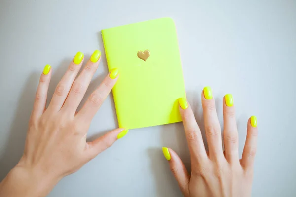 Neon yellow trendy female manicure. Nail polish.