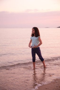 Gün batımı deniz arka plan genç kız dans.