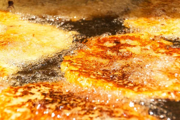 Frying potato pancakes in hot oil. Potato pancakes in a pan. Traditional meal. Greasy food. Dangers of obesity