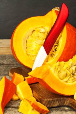 Dilimlenmiş Hokkaido balkabağı. Balkabağı çorbası hazırlanması. Sebze tarımı. Hokkaido kabak ahşap bir masa üzerinde