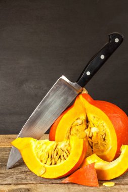 Dilimlenmiş Hokkaido balkabağı. Balkabağı çorbası hazırlanması. Sebze tarımı. Hokkaido kabak ahşap bir masa üzerinde