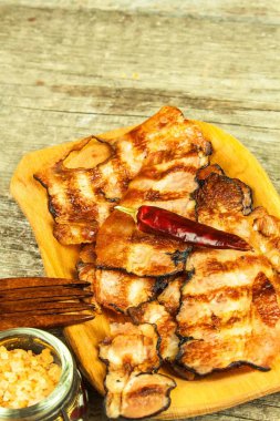 Izgara domuz pastırması. Tablo üzerinde çıtır pişmiş jambon. Sağlıksız yiyecek. Obezite riski. Ev yapımı Barbekü.