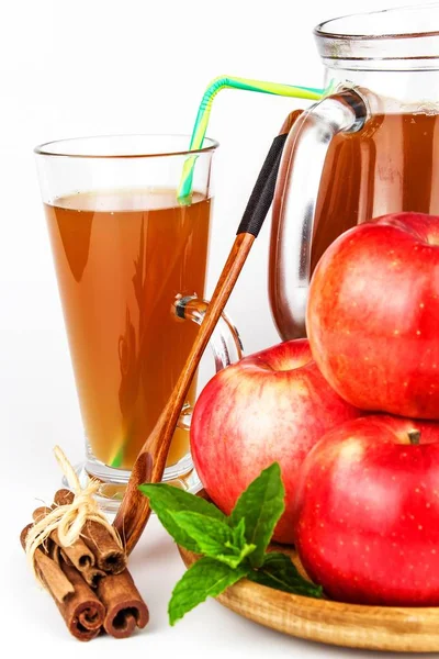 Fresh apple juice in a glass. Fruit harvest. Healthy beverage. Apples on the kitchen table. Production of juice. On a white background.