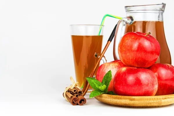 Jus de pomme frais dans un verre. Récolte de fruits. Une boisson saine. Des pommes sur la table de la cuisine. Production de jus. Sur fond blanc . — Photo