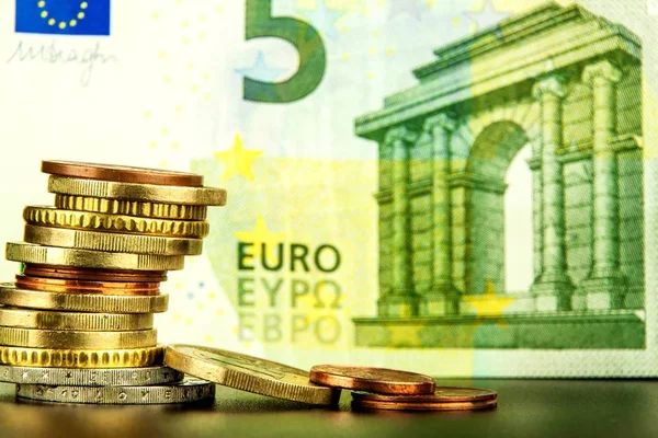 Euro coins on euro banknotes as background. Close-up of several euro coins. Concept of trading on the stock exchange. Euro exchange rate