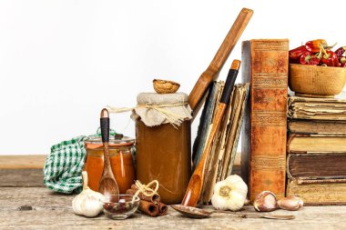 Ahşap bir masa üzerinde mutfak eşyaları. Beyaz arka plan. Yiyecek hazırlama. Yemek kitabı ve pişirme malzemeler. Eski kitap.