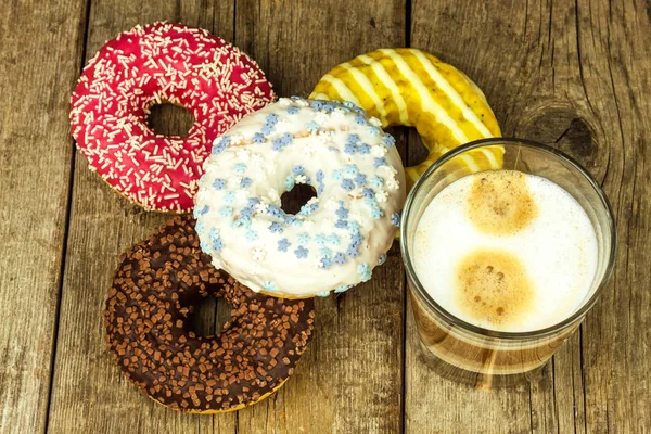 Unhealthy food. Donuts on a wooden table. Coffee to dessert. Dangers of obesity and diabetes. Sales of sweets. Donuts for breakfast.