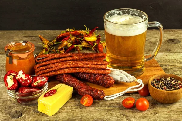 Beer and sausages on an old wooden table. Sale of beer and sausage. Food for beer. Unhealthy food.