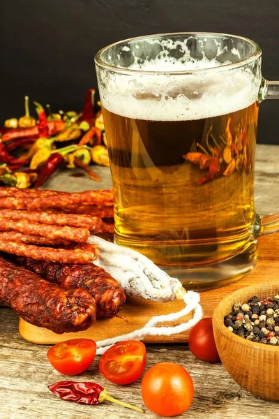 Beer and sausages on an old wooden table. Sale of beer and sausage. Food for beer. Unhealthy food.