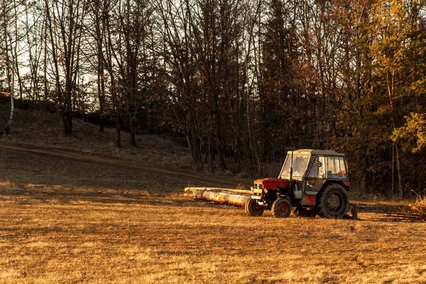 Gamla röda traktor i utkanten av en skog. Arbete i skogen. En övergiven traktor. Landskap av den tjeckiska landsbygden. — Stockfoto