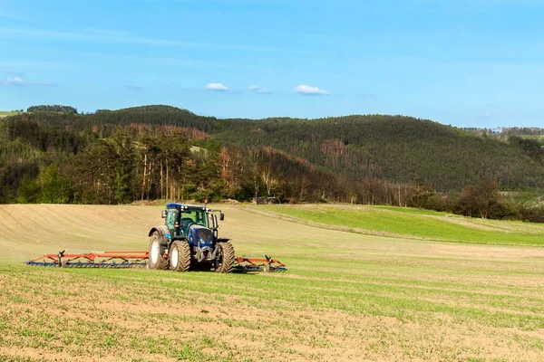 Μπλε τρακτέρ στο χωράφι. Δουλεύοντας σε ένα αγροτικό αγρόκτημα στην Τσεχική Δημοκρατία. Εαρινές εργασίες στη γεωργία. — Φωτογραφία Αρχείου