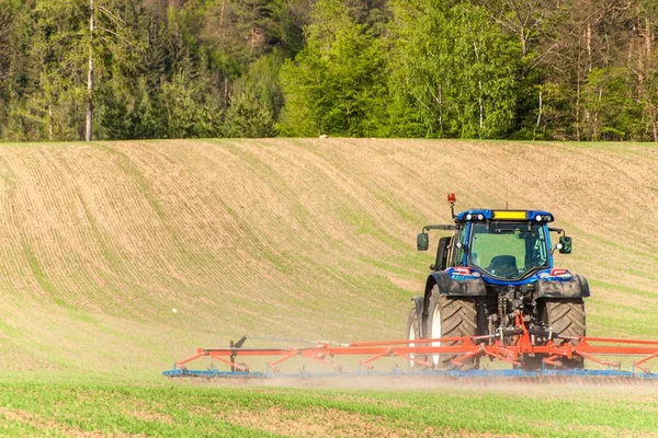 Traktor biru di lapangan. Bekerja di pertanian di Republik Ceko. Spring bekerja di pertanian . — Stok Foto